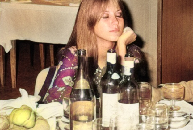 1960s woman at table with wine 1960s woman at table with wine